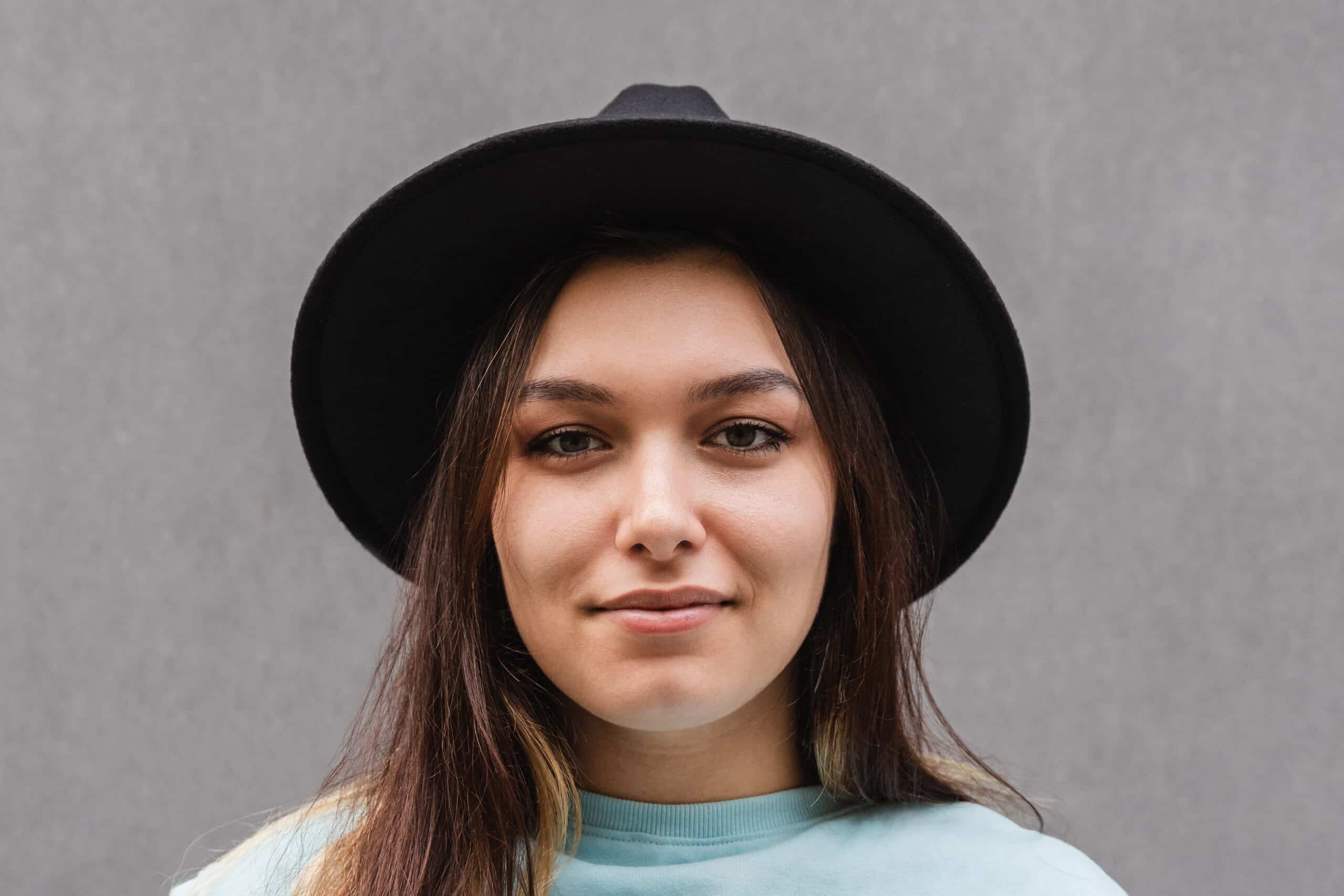 girl smiling with a black cowboy hat on