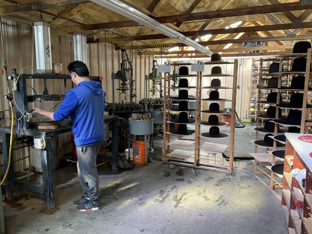 employee at twinstone hats handcrafting a cowboy hat