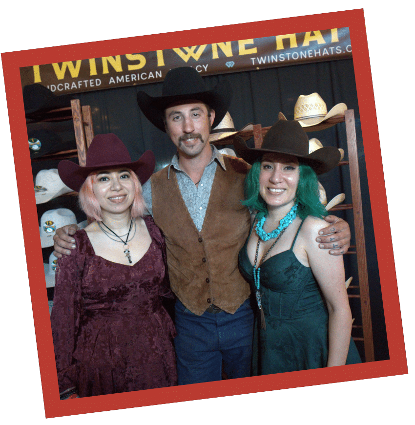 Matt Daniel and two women wearing Twinstone cowboy hats at a branded event booth display.
